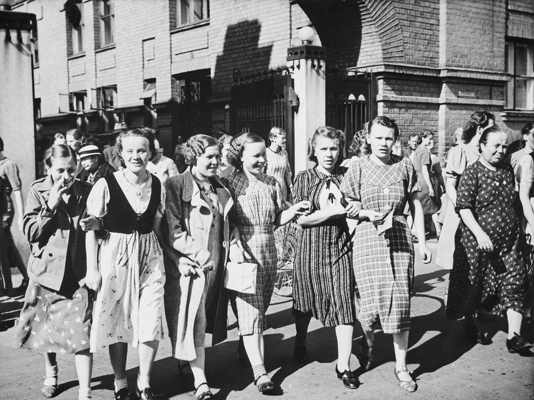 Joukko naisia kävelee Finlaysonin tehdasalueen pihalla