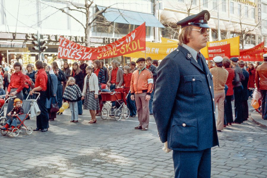 Poliisi seisoo vahtimassa kansan joukkomarssia