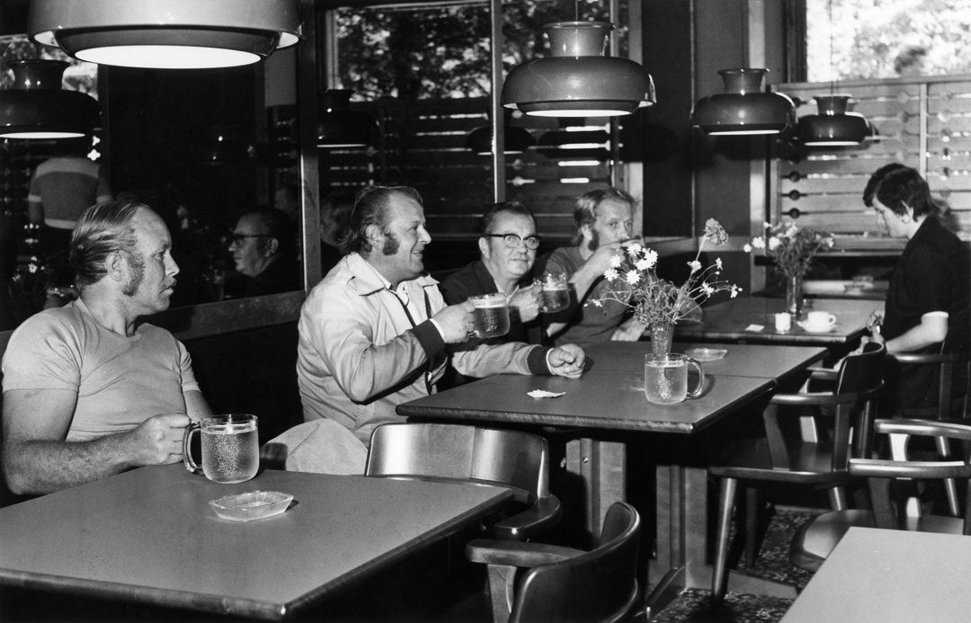 Miehet istuvat ravintolassa tuopit käsissään
