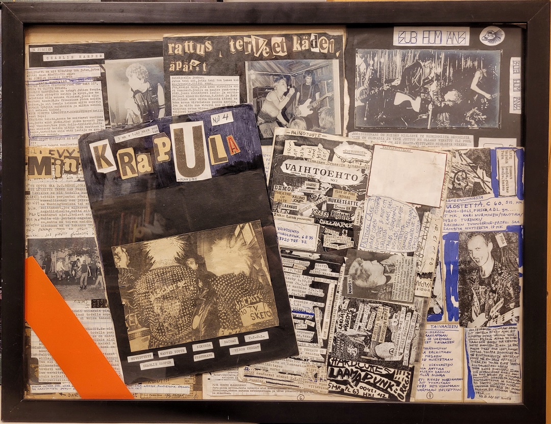 Krapula-punkzine_verkkosivuille Nainen seisoo kynä kädessä fläppitaulun edessä ja katsoo kohti kameraa. Taululle on piirettynä erilaisia eläinhahmoja.