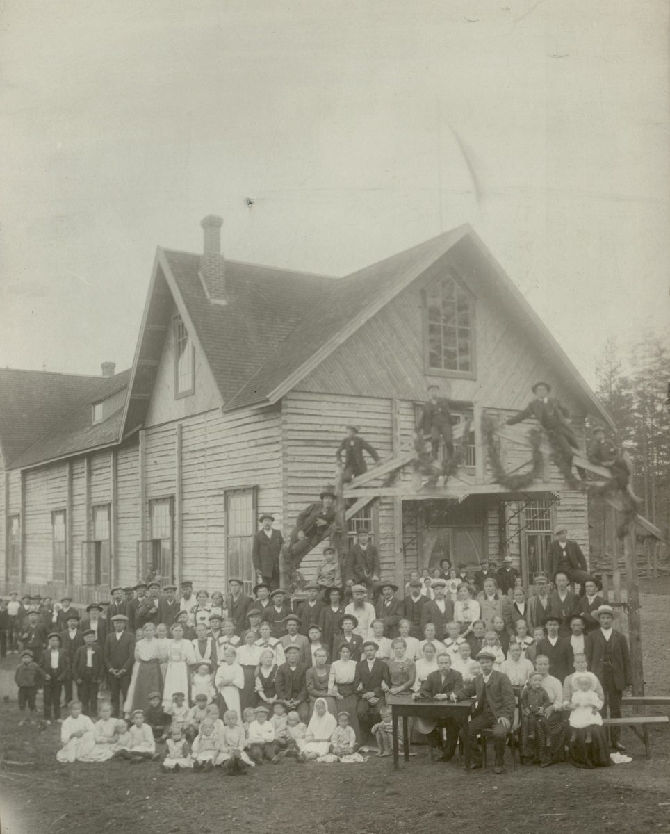 Lauritsalan_tyovaentalo_1910-luvulla_Tyovaen_arkisto Museon opas näyttää lapsiryhmälle kuvaa höyryveturista.
