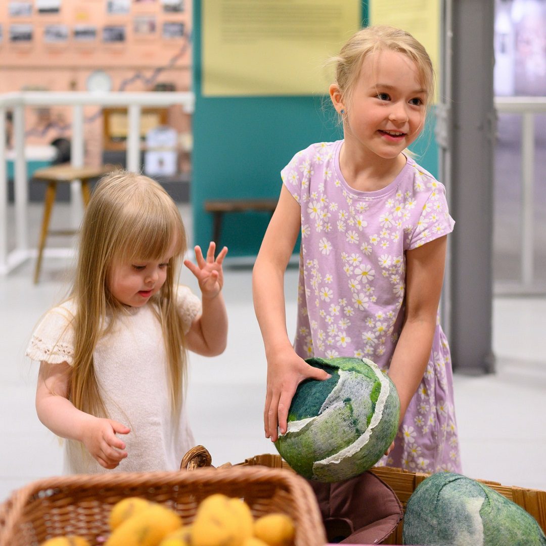 Museon opas näyttää lapsiryhmälle kuvaa höyryveturista.